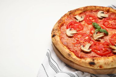 Domatesli, mantarlı ve fesleğenli leziz pizza beyaz ahşap masada, yakın plan. Metin için boşluk