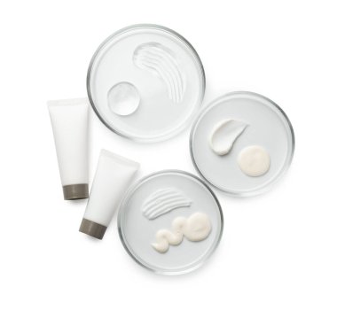 Farklı kozmetik ürünleri içeren petri kapları beyaz ve düz yerde izole edilmiş.