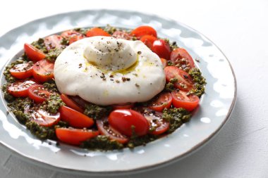 Taze lezzetli burrata salatası beyaz masada, yakın plan.