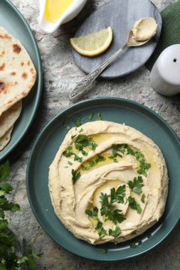 Gri desenli masada servis edilen zeytinyağlı leziz humus.