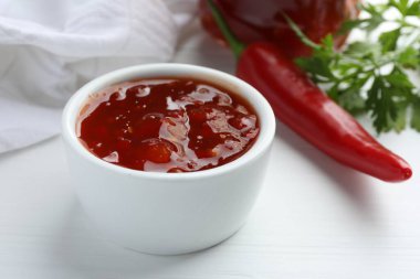 Baharatlı biber sosu beyaz ahşap masada, yakın plan.