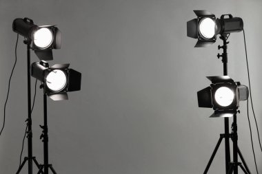 Stüdyoda gri fotoğraf ve profesyonel ışıklandırma ekipmanları