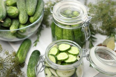 Ev yapımı turşu. Kavanozlarda taze salatalıklar ve diğer malzemeler masada, yakın plan.