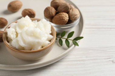Shea tereyağı kasede ve fındık beyaz ahşap masa üzerinde, metin için boşluk