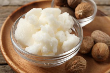 Shea tereyağı kasede fındık da ahşap masada, yakın plan.