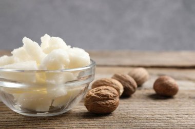 Shea tereyağı kasede ve fındıklar ahşap masada, yakın plan. Metin için boşluk