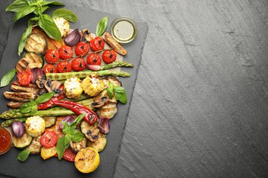 Gri dokulu masada baharatlı lezzetli ızgara sebzeler, üst manzara. Metin için boşluk