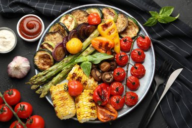 Gri masada servis edilen leziz ızgara sebzeler.