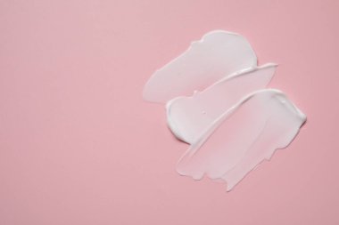 Pembe arka planda yüz kremi, üst manzara. Metin için boşluk