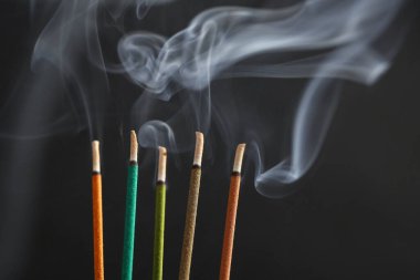 Aromatik tütsü siyah arka planda yanar.