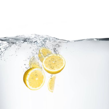 Beyaz arkaplanda suya düşen taze limonlar