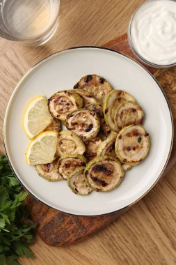 Ahşap masada servis edilen lezzetli ızgara kabak dilimleri.