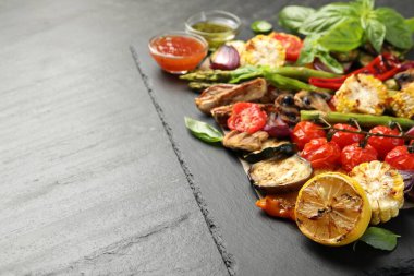 Gri desenli masada servis edilen leziz ızgara sebzeler, yakın plan. Metin için boşluk