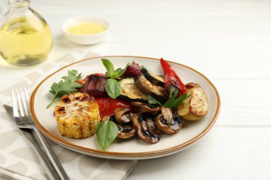 Beyaz ahşap masada servis edilen baharatlı lezzetli ızgara sebzeler.