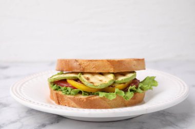 Beyaz mermer masada ızgara sebzeli lezzetli sandviç, yakın plan.