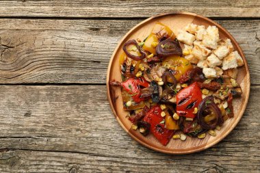 Ahşap masada ızgara sebzeli nefis salata, üst manzara. Metin için boşluk