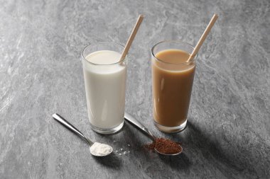 Lezzetli protein kadehleri ve gri masadaki tozlu kaşıklar.