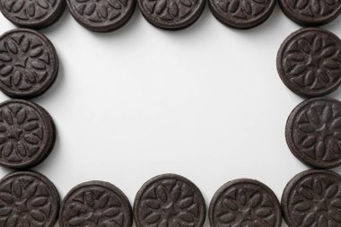 Beyaz arka planda lezzetli sandviç kurabiyeleri çerçevesi, üst manzara. Metin için boşluk