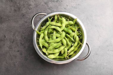 Çiğ yeşil edamame soya fasulyesi ve kapsülleri gri masada, üst manzara