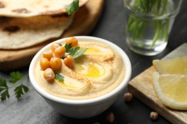 Zeytinyağlı lezzetli humus ve gri masada servis edilen nohut, yakın plan.