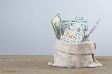 Tahta masadaki çantada dolar banknotları, metin için yer