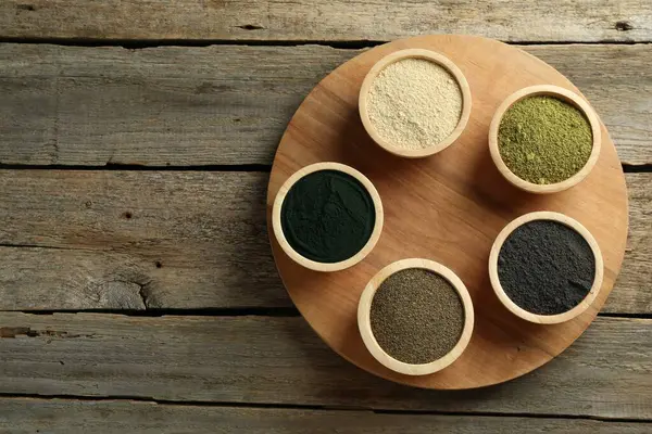 stock image Different superfood powders in bowls on wooden table, top view. Space for text