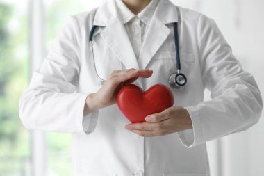 Klinikte kırmızı kalpli bir doktor, yakın plan.