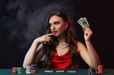 Siyah arka planda poker oynayan hoş bir kadın.