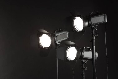 Stüdyoda karanlık fotoğraf arkaplanı ve profesyonel ışıklandırma ekipmanları