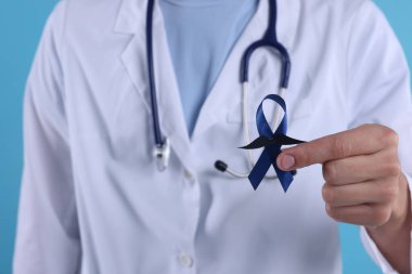 Prostat kanseri farkındalığı. Doktor elinde sahte bıyıklı mavi kurdele tutuyor.