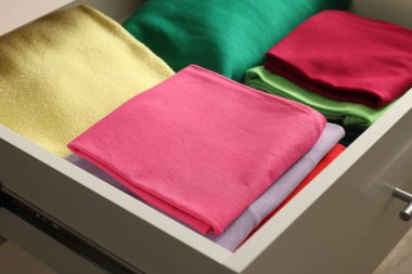 Farklı katlanmış elbiseli çekmeceler, yakın plan.