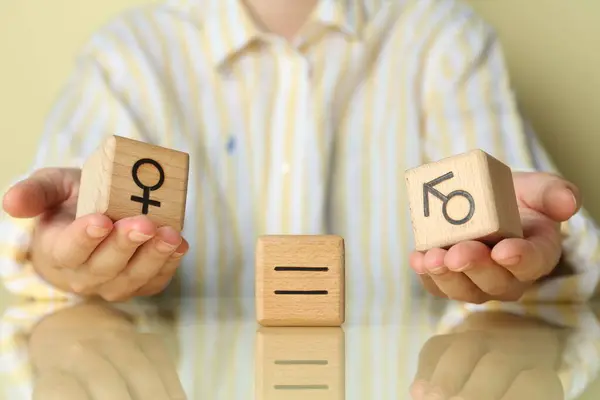 stock image Gender equality concept. Woman with wooden cubes of male and female symbols at table, closeup