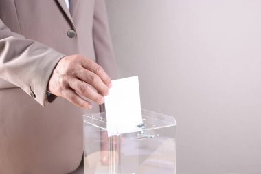 Adam oyunu açık gri arka plana karşı sandığa koyuyor, yakın plan. Metin için boşluk