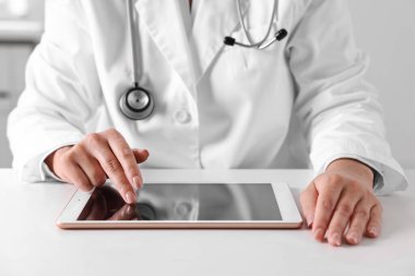 Klinikteki masada tabletli doktor, yakın çekim.