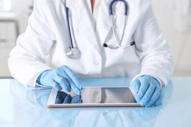 Klinikteki masada tabletli doktor, yakın çekim.