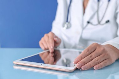 Tableti mavi arkaplanda olan doktor, görüntüyü kapat