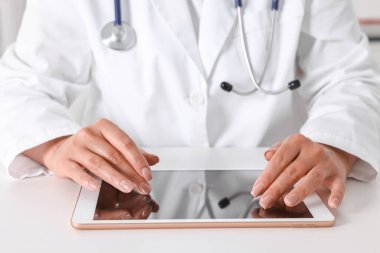 Klinikteki masada tabletli doktor, yakın çekim.