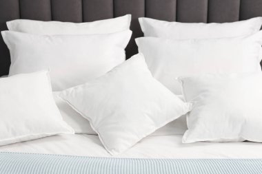 Evdeki yatakta bir sürü yumuşak yastık, yakın çekim.