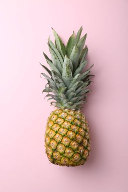 Pembe arka planda taze, olgun bir ananas.