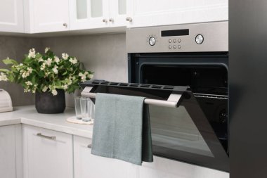 Mutfakta havluyla elektrikli fırını aç. Yemek pişirme aygıtı
