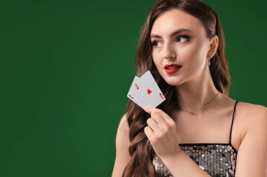 Poker oyunu. Yeşil arka planda oyun kartları olan çekici bir kadın. Metin için boşluk