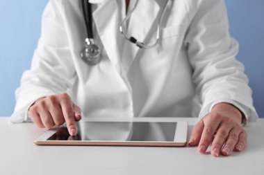 Tabletli doktor açık mavi arkaplanda, yakın görünüm