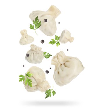 Delicious khinkali (Georgian dumplings), peppercorns and parsley falling on white background clipart