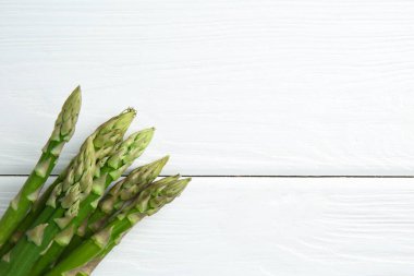 Taze yeşil kuşkonmaz, beyaz ahşap masa, üst manzara. Metin için boşluk