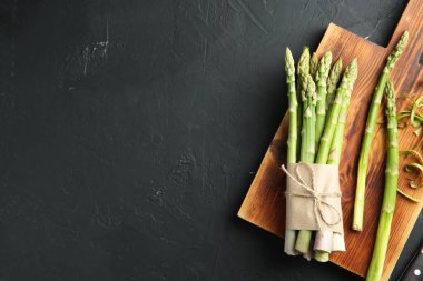 Taze yeşil kuşkonmaz, gri desenli masa üzerinde düz yatar. Metin için boşluk