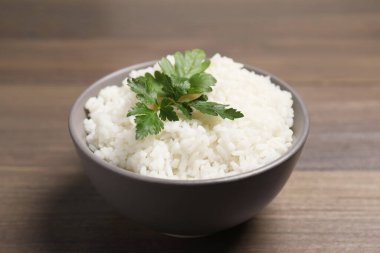 Tahta masada maydanozlu bir kase lezzetli haşlanmış pirinç, yakın plan.