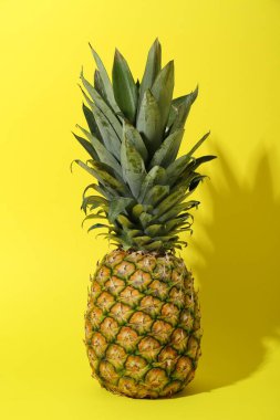 Sarı arka planda taze olgun bir ananas