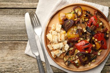 Ahşap masada servis edilen ızgara sebzeli leziz salata.