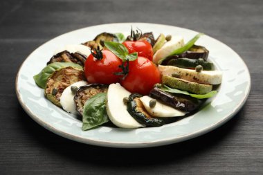 Izgara sebzeli lezzetli salata ve ahşap masada mozzarella peyniri, yakın plan.