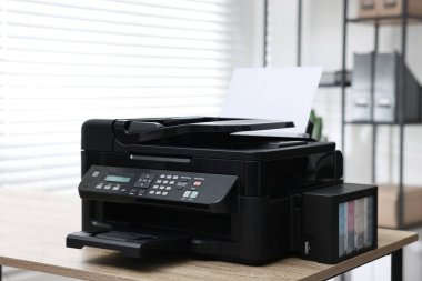 Modern printer with paper on table in office clipart